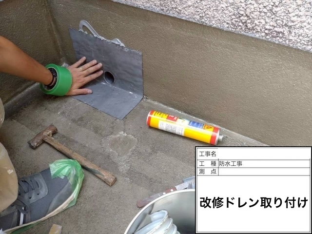 雨漏り対策の要となる改修用ドレンの取り付け作業。既存の排水口に鉛製のドレンを設置し防水機能を強化。